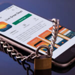 Picture of a smartphone lying on a table with a padlock and chain around it