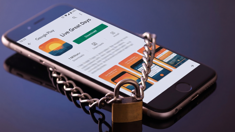 Picture of a smartphone lying on a table with a padlock and chain around it